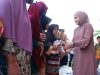 Ketua TP PKK Labusel, Ny. Indah Fery Simatupang, tersenyum hangat saat membagikan bantuan kepada para lansia.