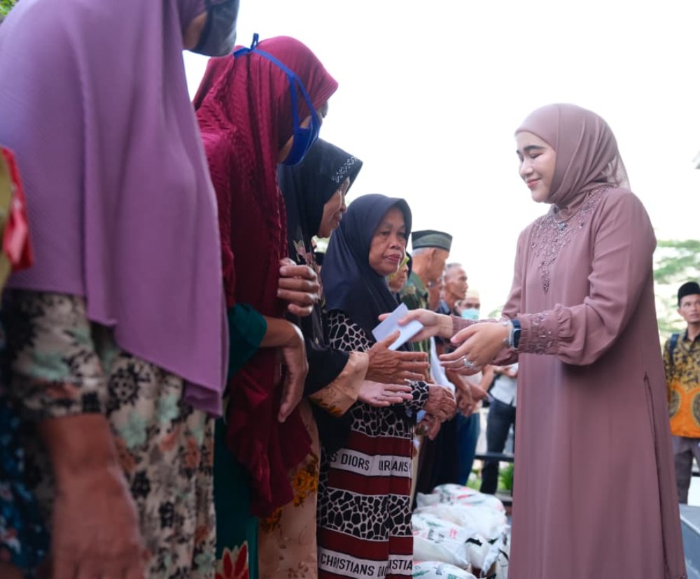 Ketua TP PKK Labusel, Ny. Indah Fery Simatupang, tersenyum hangat saat membagikan bantuan kepada para lansia.