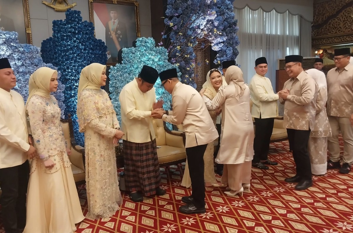 Seluruh kerabat tampak serasi dalam balutan kemeja koko dan gaun berhijab bernuansa krem, memperkuat makna keindahan kebersamaan di hari kemenangan."