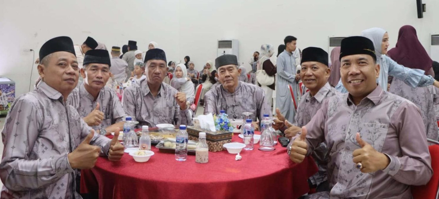 Enam anggota Polres OKU mengenakan seragam koko serasi dan peci hitam duduk mengelilingi meja bundar sambil tersenyum dan berpose jempol di acara halal bihalal.