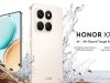 Iklan dinamis bergaya produk menampilkan dua unit smartphone HONOR X7d 5G dalam warna krim sampanye. Ponsel belakang memiliki modul kamera empat lensa persegi dan logo HONOR di bagian bawah, sedangkan ponsel depan menampilkan layar melengkung dengan wallpaper berwarna.