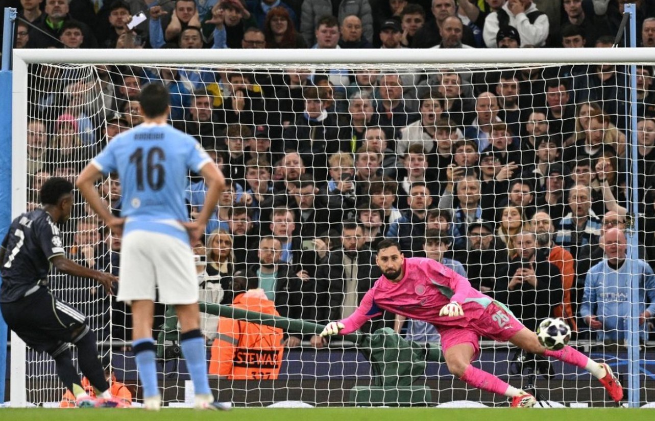 Pemain Real Madrid Vinicius Junior mengeksekusi tendangan penalti ke gawang kiper Manchester City Gianluigi Donnarumma.