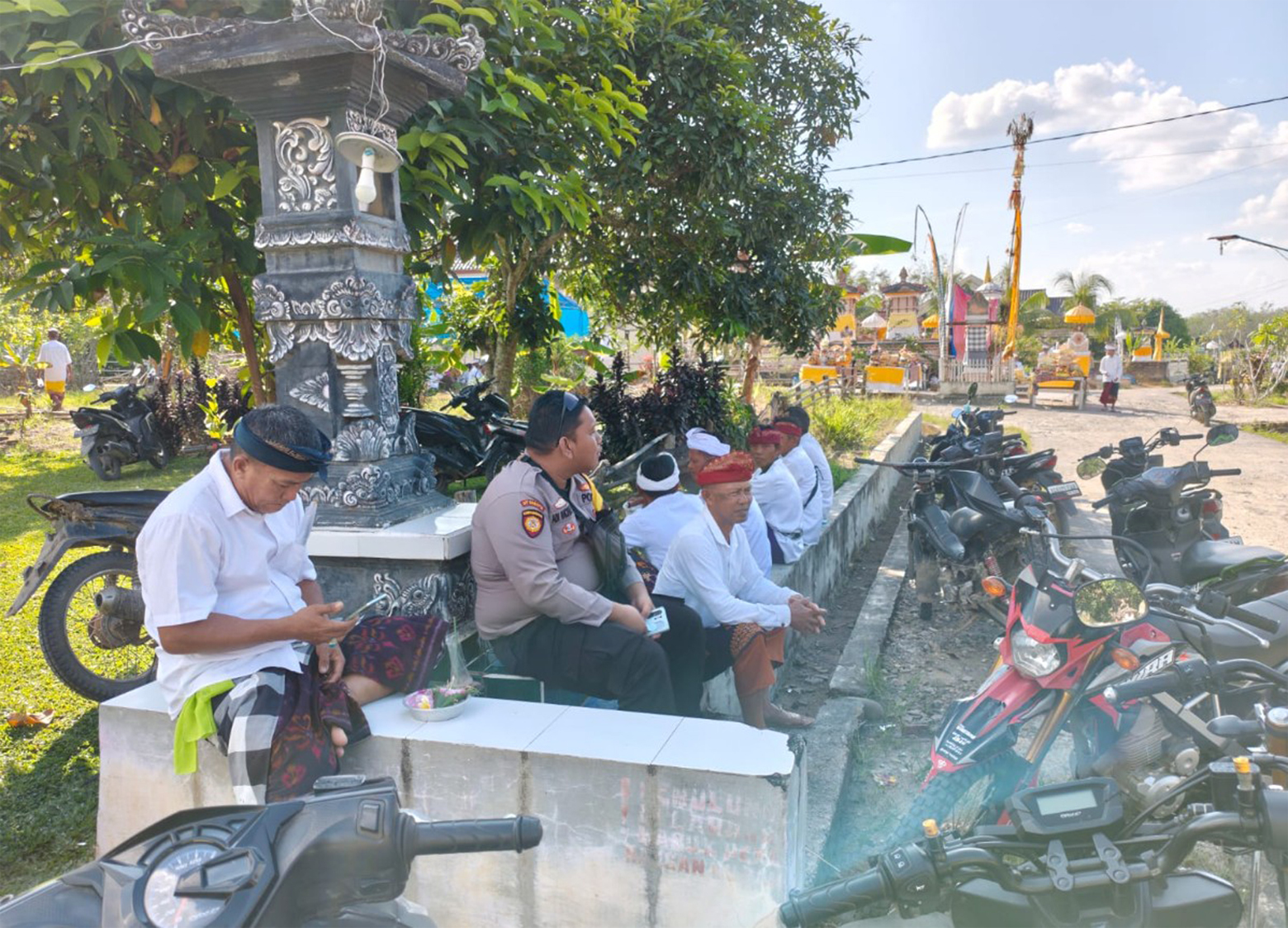 Seorang Polsek Peninjauan berkoordinasi dengan warga berpakaian adat dan polisi berpakaian preman.