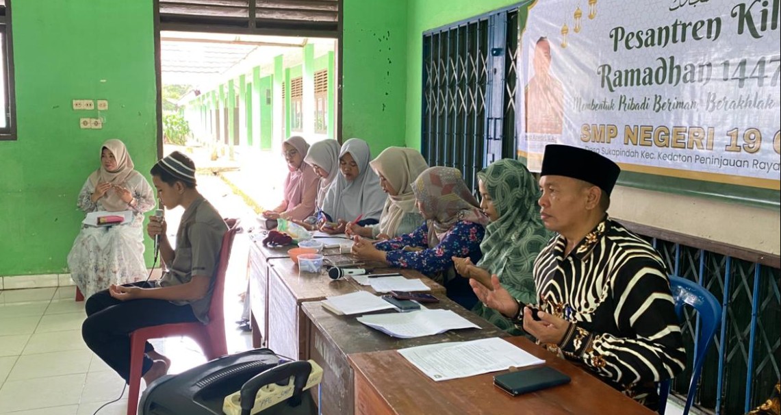Seorang siswa SMPN 19 OKU khusyuk mengikuti lomba hafalan surah pendek. Dewan guru tampak serius memberikan penilaian secara langsung.