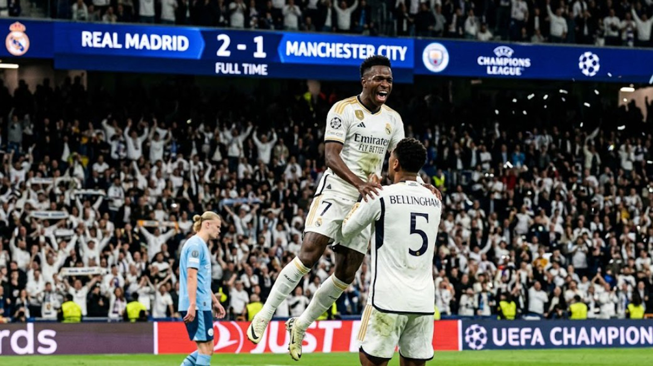 Pemain Real Madrid, Vinicius Junior, merayakannya dengan melompat ke pelukan Jude Bellingham di lapangan Santiago Bernabeu setelah mengalahkan Manchester City 2-1 di Liga Champions.