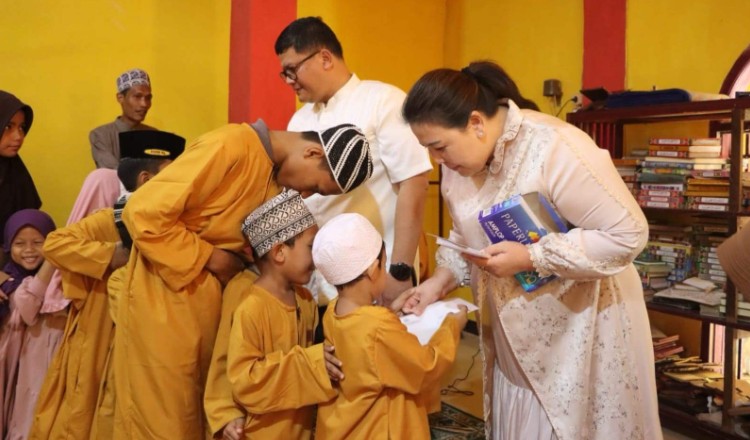 MOMEN HANGAT KEBERSAMAAN :  Kapolres OKU AKBP Endro Aribowo didampingi Ketua Bhayangkari Cabang OKU Ny. Ivonne Endro Aribowo memberikan santunan kepada anak-anak yang berbaris rapi di bulan penuh berkah ini. Keikhlasan memberi membawa senyum di wajah mereka.