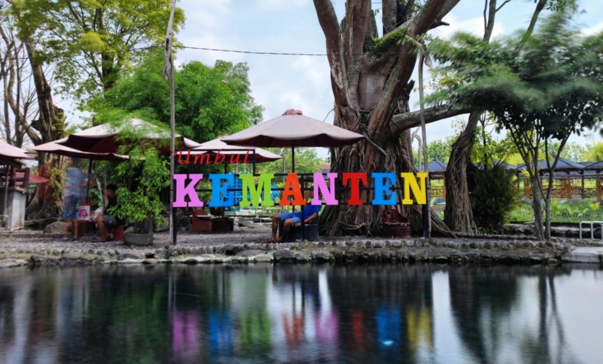 Kolam mata air jernih Umbul Kemanten di Desa Wisata Sidowayah Klaten di bawah pohon rindang.
