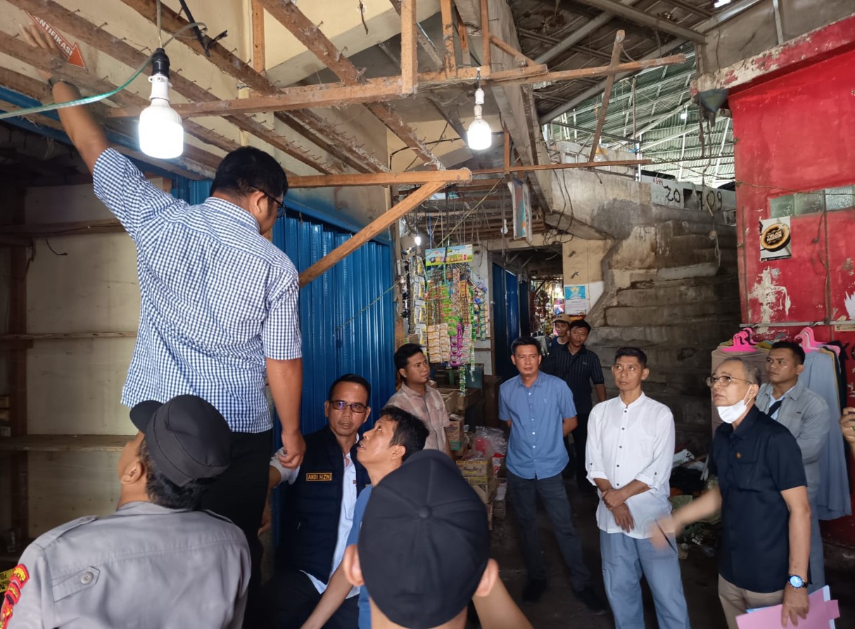 Anggota Polsek Baturaja Timur, Aiptu Agus Trisandi SE dipimpin Kanit Reskrim Polsek Baturaja Timur, Ipda Andi Hendrianto melakukan olah TKP ulang di depan kios B - 19 Pasar Atas Baturaja yang dipasang garis polisi sejak, Selasa, 17 Maret 2026.
