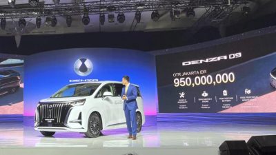 Mobil MPV listrik premium BYD Denza D9 berwarna putih dipamerkan di atas panggung peluncuran dengan latar layar LED menampilkan harga Rp950 juta.