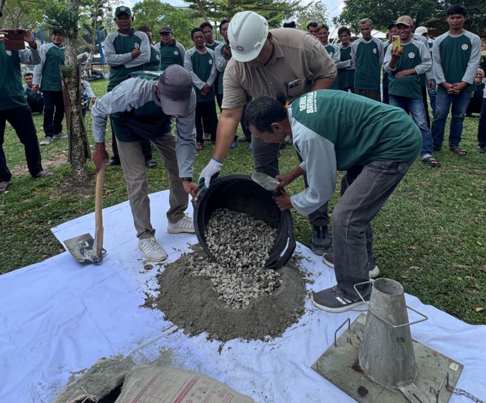Peserta Akademi Jago Bangunan sedang mencampur kerikil dan semen Baturaja saat praktik lapangan di OKI.