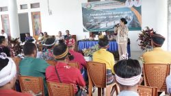 Bupati Sumba Barat Daya, Ratu Ngadu Bonnu Wulla menyampaikan kepada warga latar belakang bertuliskan 'SOSIALISASI PENANGANAN LONG SEGMEN JALAN OMBARADE - KALIMBU TILLU'. Audiens difoto dari belakang, beberapa mengenakan penutup kepala tradisional Sumba. Latar belakangnya adalah bangunan semi-terbuka dengan tanaman hias.