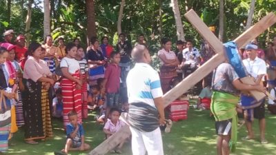Umat Stasi Sang Penebus Tambagha menyaksikan prosesi Jalan Salib hidup dengan khidmat di bawah pepohonan.