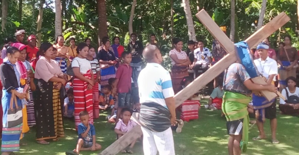 Umat Stasi Sang Penebus Tambagha menyaksikan prosesi Jalan Salib hidup dengan khidmat di bawah pepohonan.