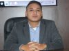 Potret Aktivis Kabupaten OKU Ahmad Mubasyir S.P CPLA mengenakan jas abu-abu duduk di meja kerja.