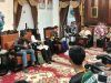 Bupati OKU Teddy Meilwansyah berbaju batik formal duduk memberikan motivasi kepada tim voli muda AVOKU (baju olahraga hijau dan kuning) yang duduk di hadapannya di ruang tamu formal pendopo rumah dinas.