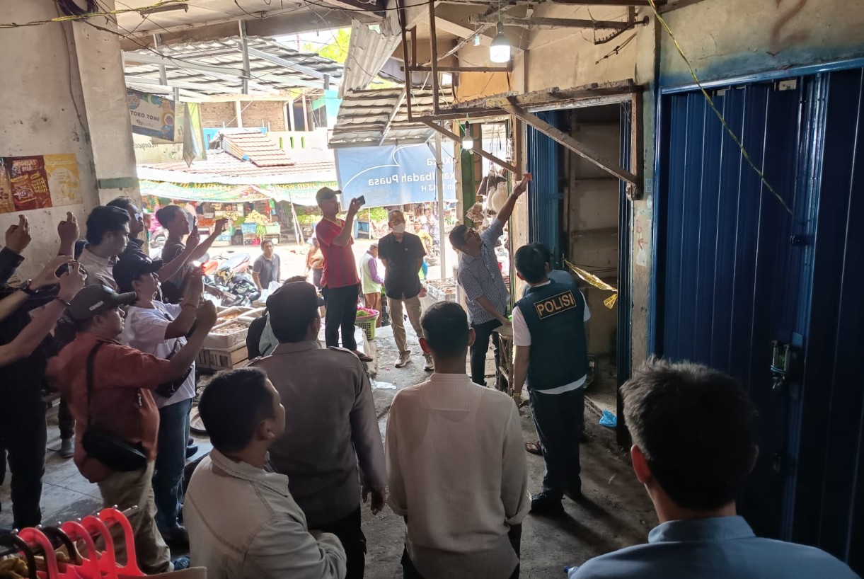 Suasana olah TKP ulang penyegelan kios oleh polisi di Pasar Atas Baturaja yang disaksikan warga.
