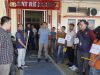 Tersangka berbaju oranye dan sejumlah saksi memegang papan nama saat proses rekonstruksi kasus pembunuhan Desa Pelangki di depan kantor Sat Reskrim Polres OKU Selatan.