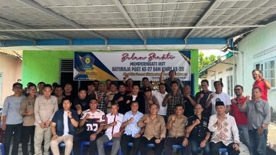 Puluhan orang berfoto bersama mengepalkan tangan di depan spanduk HUT Baturaja Post ke-27 dan KWRI OKU Raya.