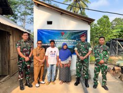 ultah 14 Skadron 12 Amur Jaya Yudha.jpg, adalah foto bersama yang lebih besar yang diambil di depan teras sebuah bangunan (posko atau bangunan fasilitas umum). Sekelompok personel TNI, baik yang berdiri maupun jongkok, bersama beberapa warga sipil, berpose serempak dengan simbol tangan "persatuan" (tangan disilangkan di dada). Di belakang mereka, spanduk besar dan jelas bertuliskan "KARYA BAKTI TNI DALAM RANGKA HUT KE-14 SKADRON 12/AMU JAYA YUDHA". Foto ini menunjukkan semangat kebersamaan dan kekompakan antara TNI dan masyarakat. Bangunan di belakang memiliki atap genteng merah yang khas.