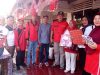 Warga dan pengurus RT 01 RW 03 Kelurahan Sukaraya Baturaja berfoto bersama sambil memegang hadiah kado lomba di teras berhias ornamen merah putih.