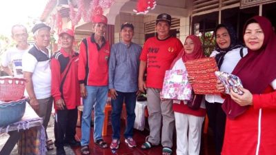Warga dan pengurus RT 01 RW 03 Kelurahan Sukaraya Baturaja berfoto bersama sambil memegang hadiah kado lomba di teras berhias ornamen merah putih.