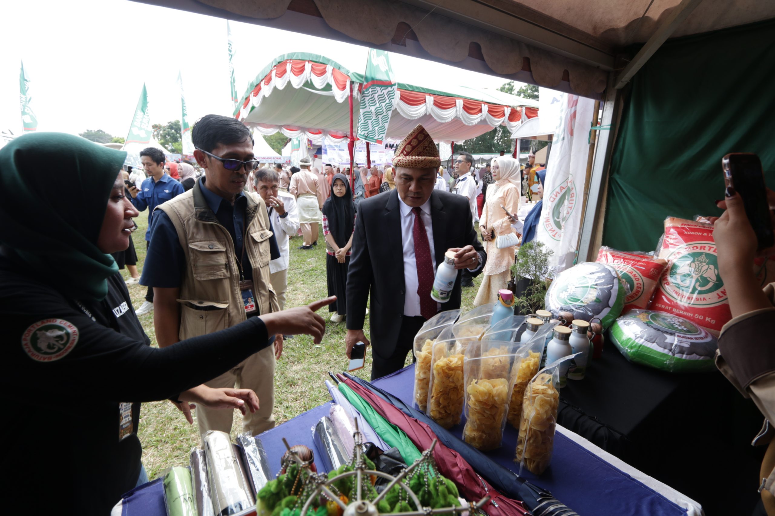 Pejabat daerah meninjau produk UMKM binaan di booth pameran PT Semen Baturaja pada perayaan HUT OKU ke-116.