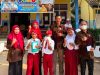Sekelompok guru dan siswa SD Negeri 183 OKU berpose ceria di depan gedung sekolah yang dihiasi spanduk PPDB dan bendera Merah Putih.