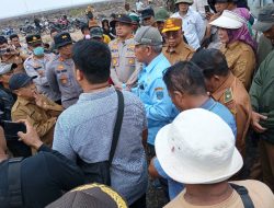 Kerumunan pejabat Pemkab OKU, Pemkab OKU Timur, warga, dan dua Kapolres berdiskusi alot di tengah lahan gambut yang terbuka.