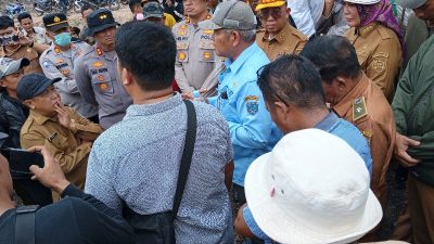 Kerumunan pejabat Pemkab OKU, Pemkab OKU Timur, warga, dan dua Kapolres berdiskusi alot di tengah lahan gambut yang terbuka.