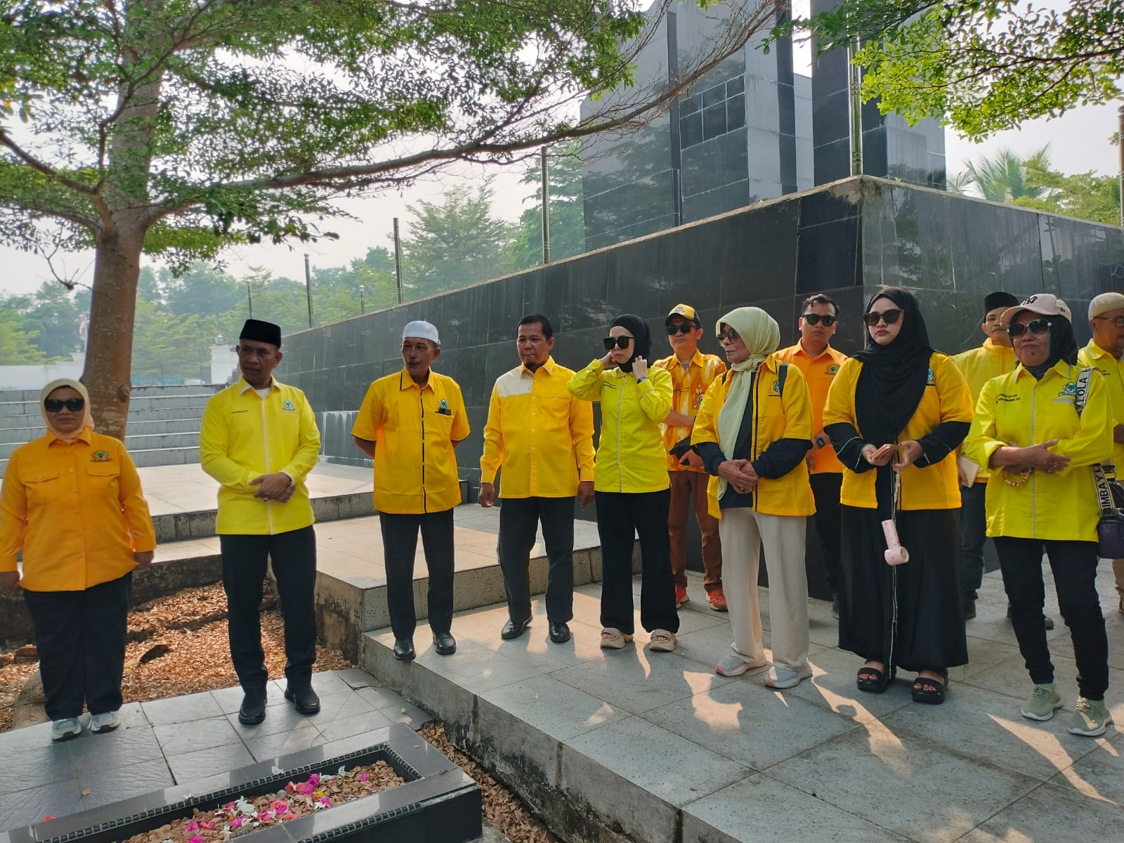 Rombongan pengurus Partai Golkar OKU berpakaian kuning sedang berziarah dan berdiri khidmat di Taman Makam Pahlawan Kemarung.