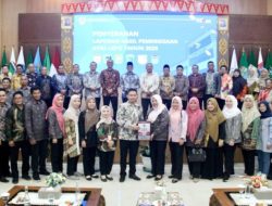 Bupati OKU Teddy Meilwansyah menerima dokumen Laporan Hasil Pemeriksaan LKPD Tahun 2025 dari pejabat BPK RI Perwakilan Sumsel saat foto bersama pejabat daerah.