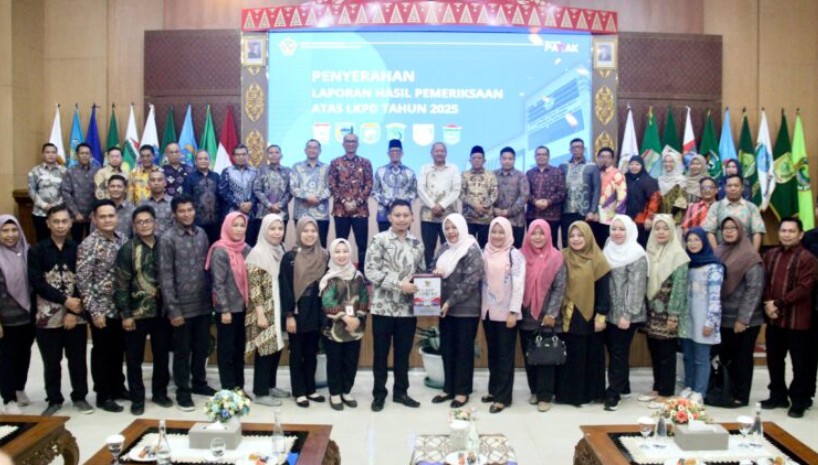 Bupati OKU Teddy Meilwansyah menerima dokumen Laporan Hasil Pemeriksaan LKPD Tahun 2025 dari pejabat BPK RI Perwakilan Sumsel saat foto bersama pejabat daerah.