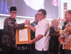 Bupati OKU Teddy Meilwansyah tersenyum saat berjabat tangan dan menerima bingkai sertifikat Kekayaan Intelektual Komunal Tari Nyambai Ugan dari perwakilan Kementerian Hukum RI di Hotel Aryaduta Palembang.