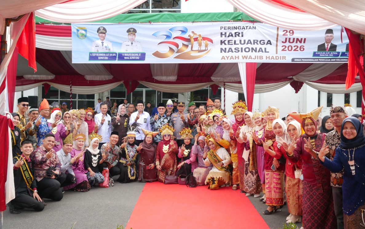 Wakil Bupati OKU Marjito Bachri bersama jajaran pejabat Pemkab OKU dan peserta berpakaian adat foto bersama di bawah spanduk Peringatan Hari Keluarga Nasional 29 Juni 2026 bertema Ayah Wajib Hadir.