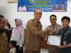 Pejabat pemerintah daerah berjabat tangan menyerahkan sertifikat kepada perwakilan PT Abadi Ogan Cemerlang.