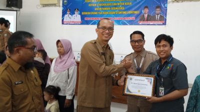 Pejabat pemerintah daerah berjabat tangan menyerahkan sertifikat kepada perwakilan PT Abadi Ogan Cemerlang.